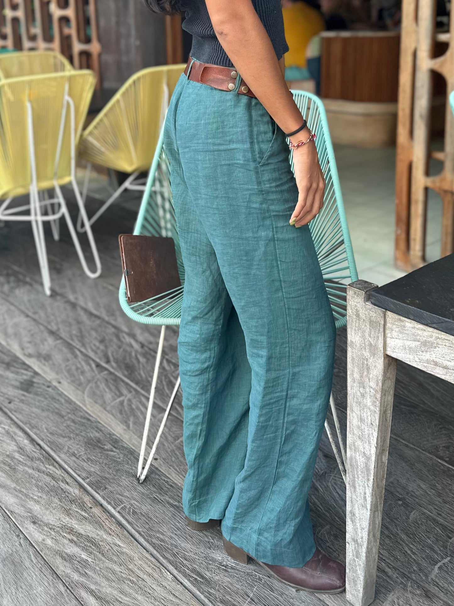 Person wearing teal pants standing at a table on the deck at Lacalita restaurant