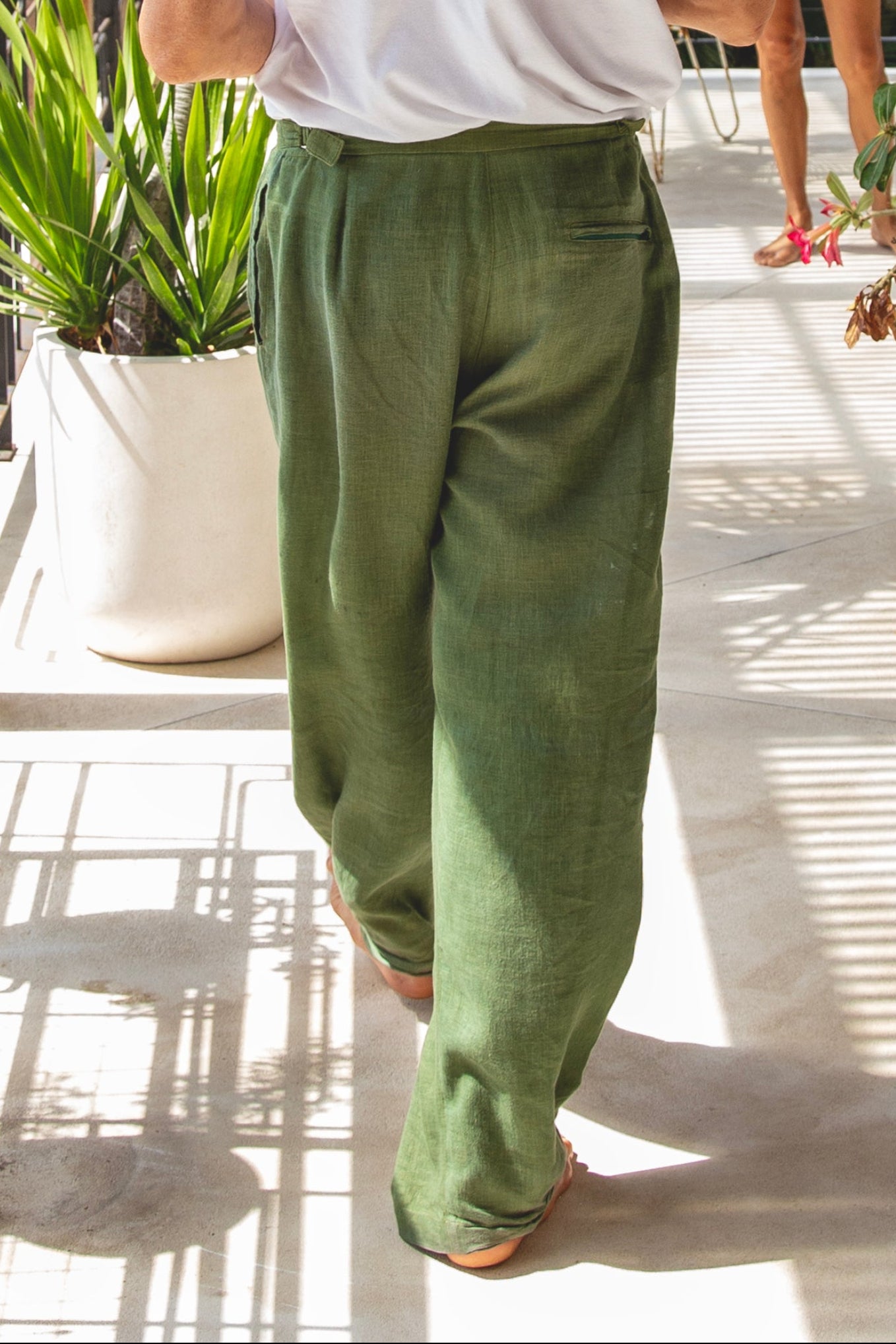 Baggy green linen pants being worn in Bali on the balcony at home 
